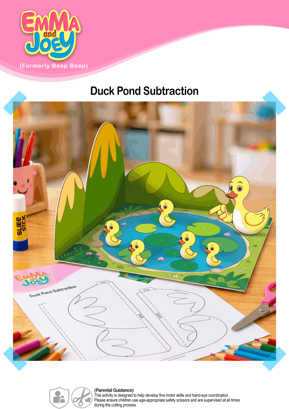 A promotional photo for the Emma and Joey 'Duck Pond Subtraction' activity. A completed 3D paper craft featuring a blue pond, a mother duck, and five small yellow ducklings stands against a paper hill backdrop on a wooden desk. In the foreground, there are colored pencils, safety scissors, a glue stick, and a printed black-and-white worksheet showing the hill cutouts.
