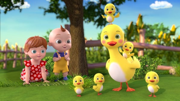 Emma and Joey playing near a river next to a mother duck and her five small yellow ducklings.