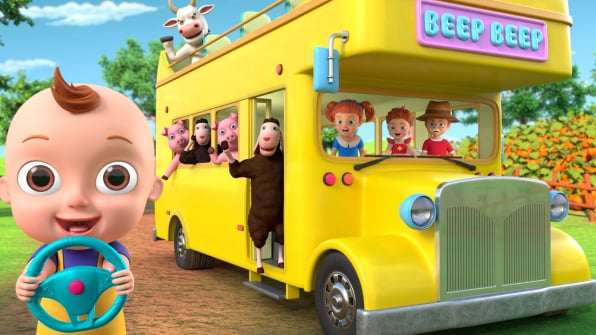 A colorful toy bus with chairs on the roof driving past a farmhouse, driven by Johny with friendly farm animals like cows, pigs, and sheep getting on board. (Note: It is best practice to keep alt text descriptive and under 125 characters so screen readers process it easily.)
